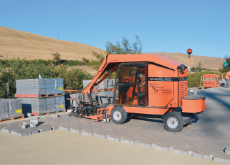 Machine-assisted installation of interlocking concrete pavement in Westley, CA.